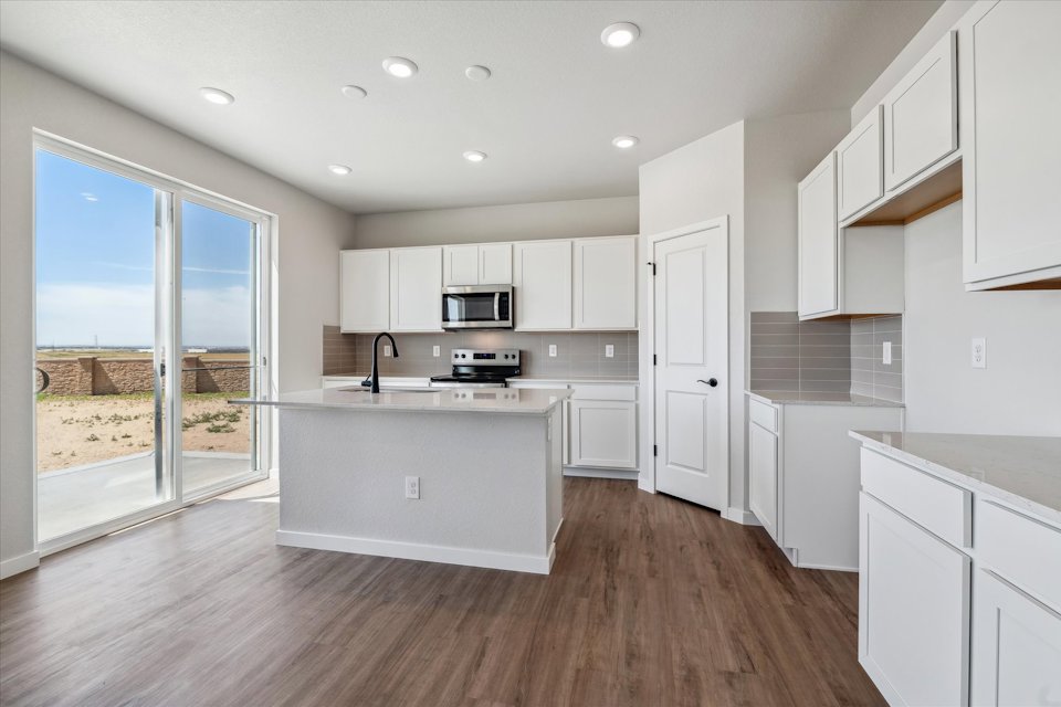 A kitchen with white cabinets.