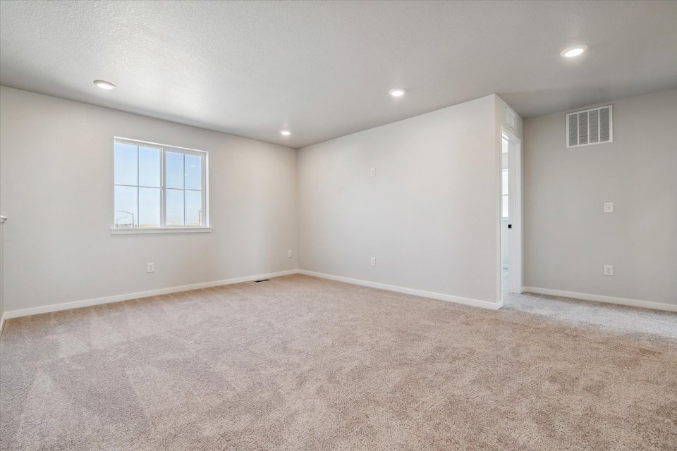 A room with a carpet and a window.