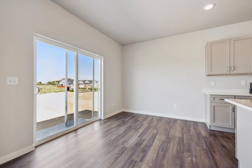 A room with a wood floor and a glass door.