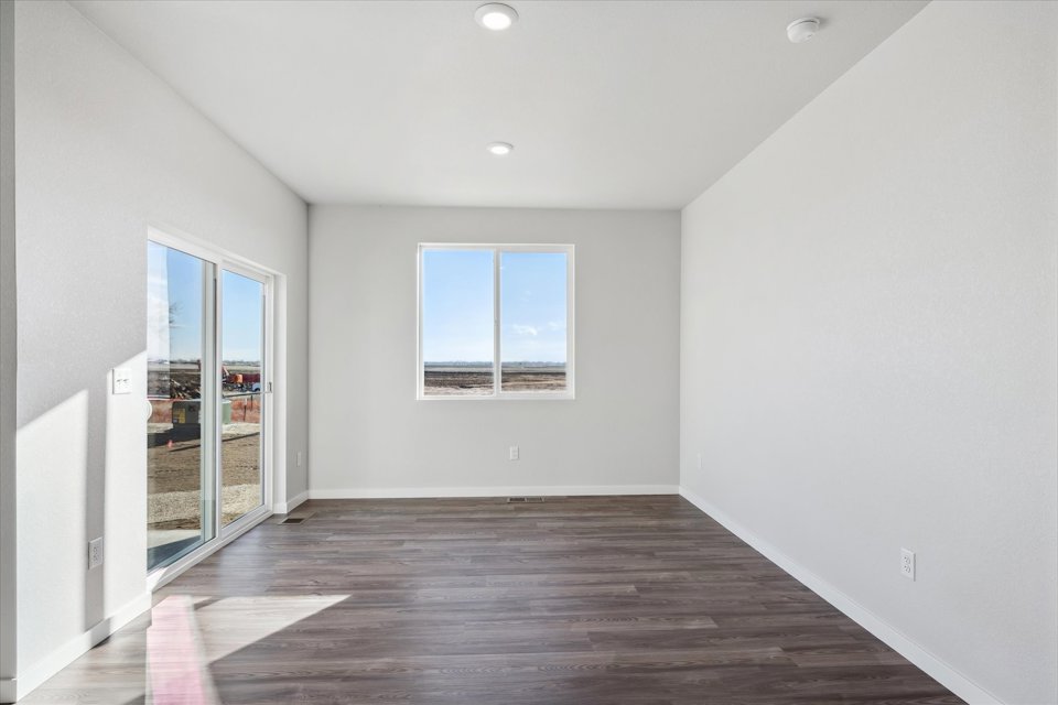 A room with a wood floor and a wood floor with a window.