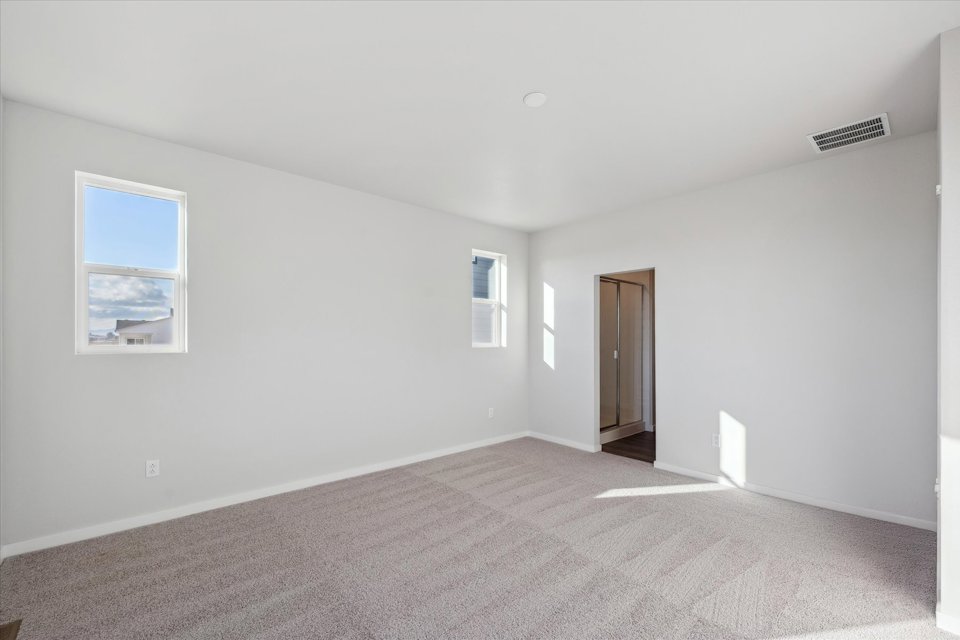 A room with a carpet and a door.
