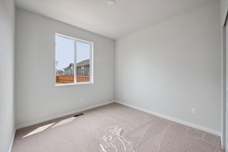 A room with a window and carpet.