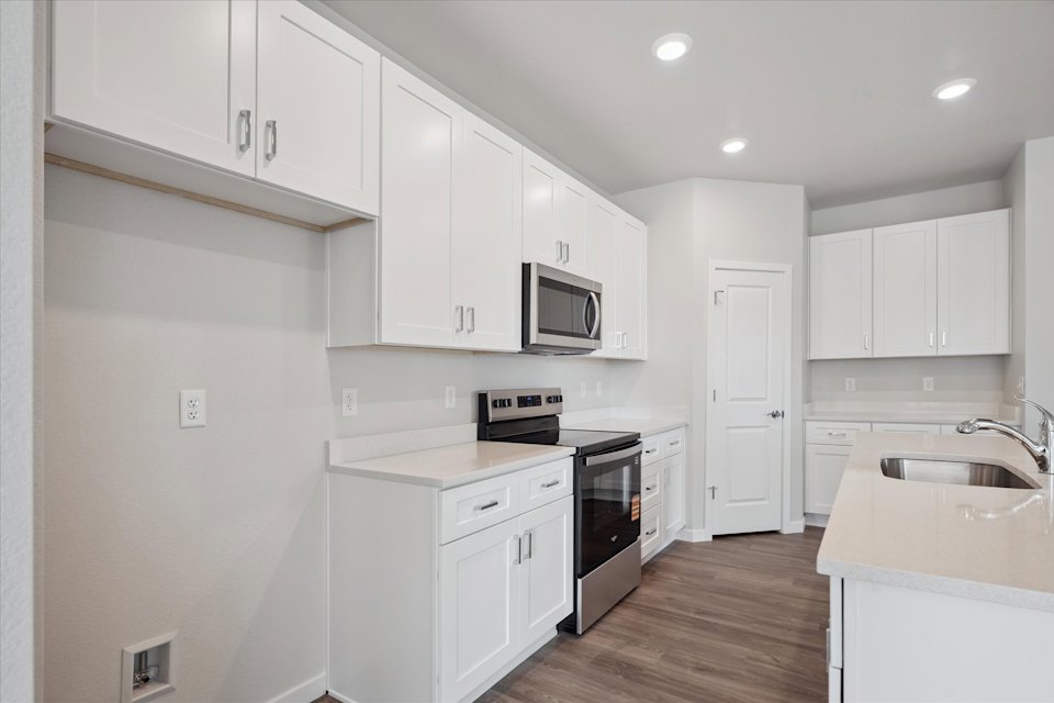 A kitchen with white cabinets.