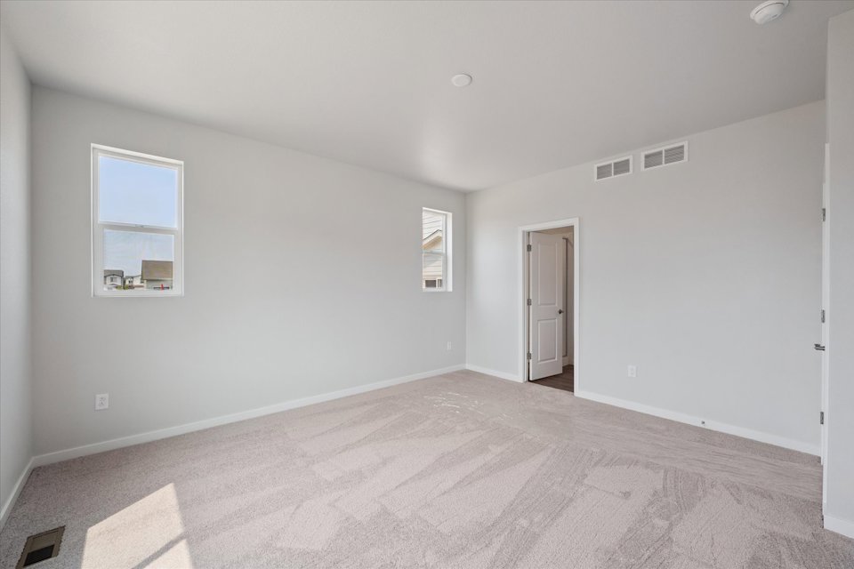 A room with a carpet and a door.