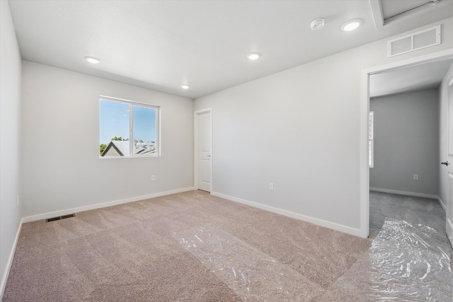 A room with a carpet and a window.