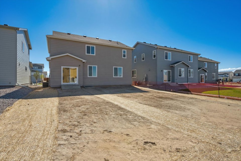 A dirt road leading to a house.