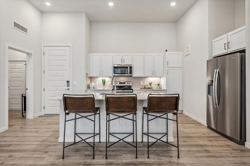 A kitchen with a table and chairs.