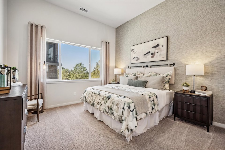 A bedroom with a large window.