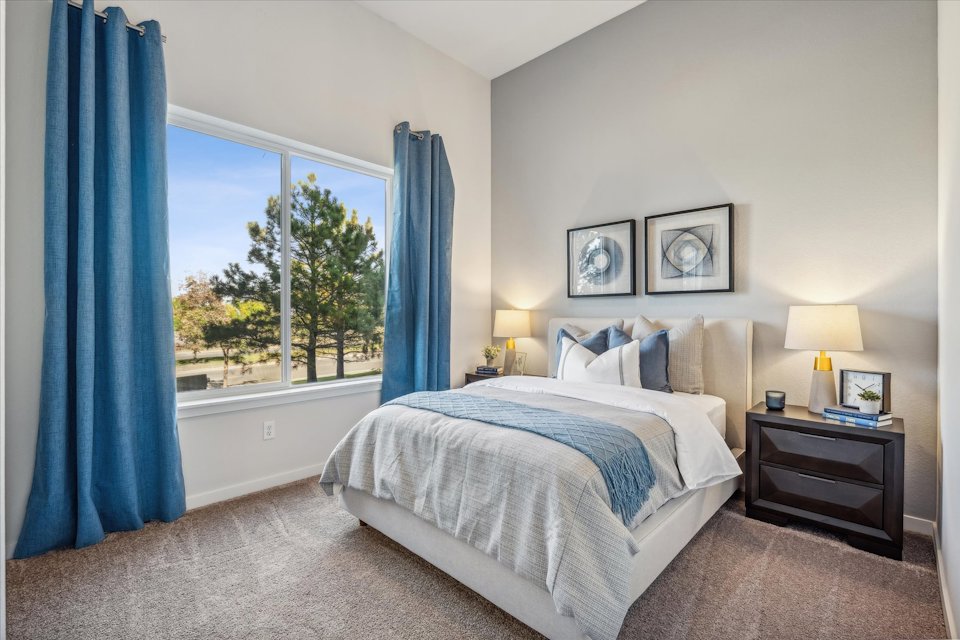 A bedroom with a large window.