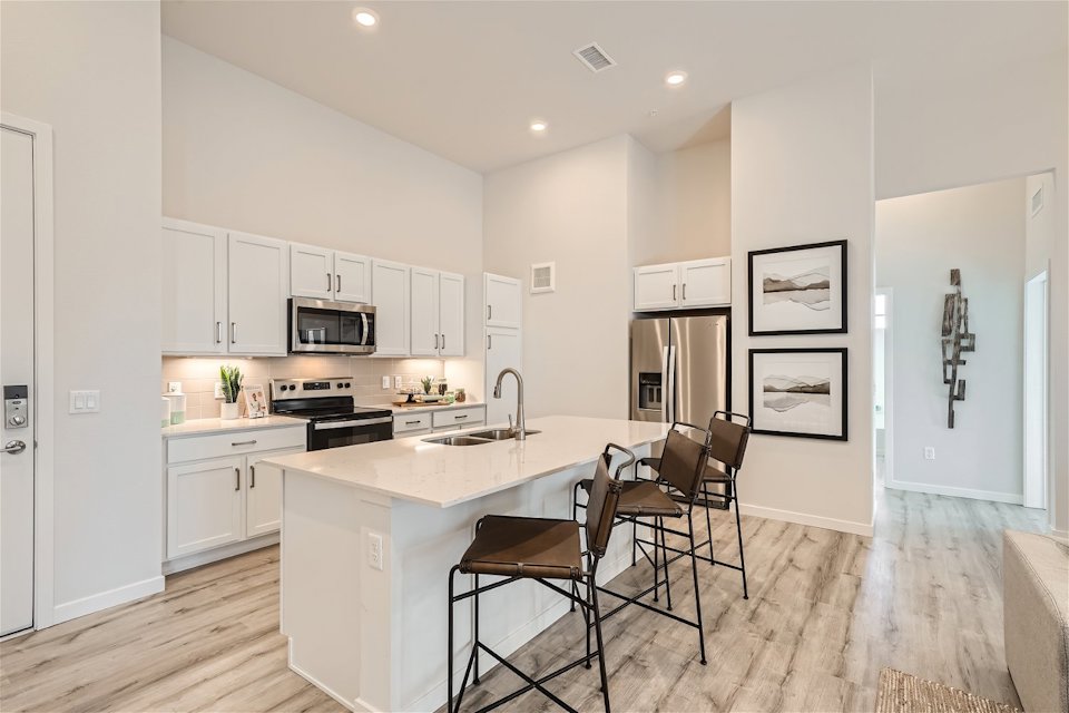 A kitchen with white cabinets.