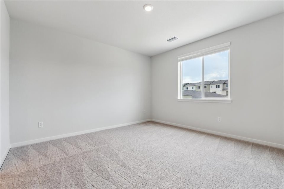A room with a window and a carpet.