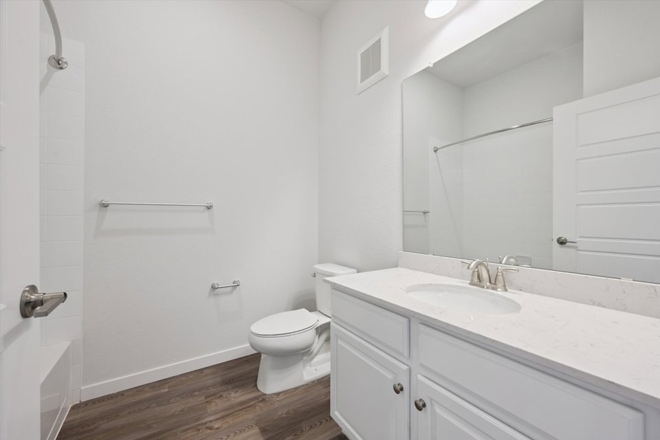 A bathroom with a toilet sink and a mirror.