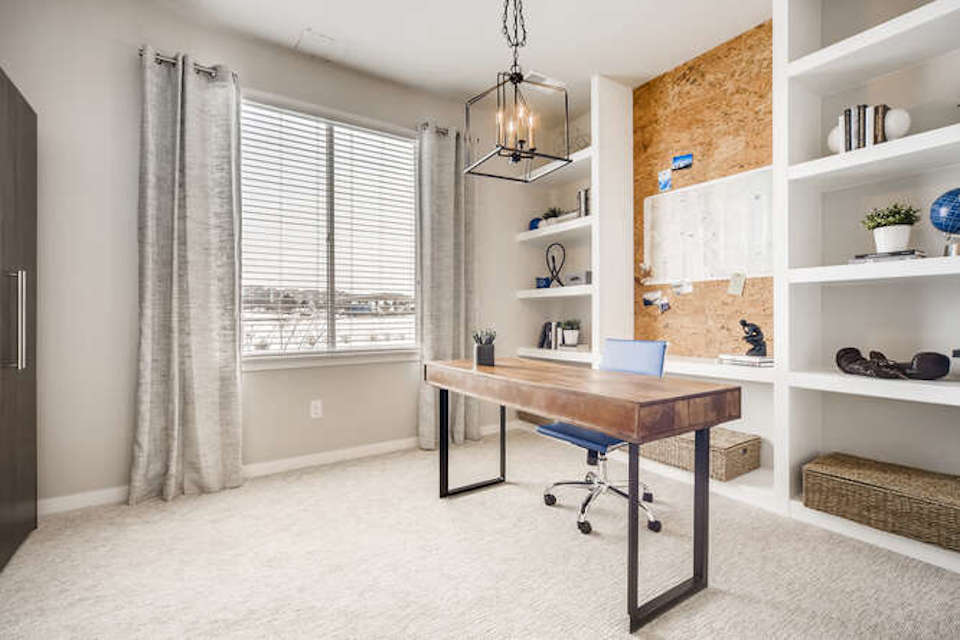 A room with a desk and shelves.