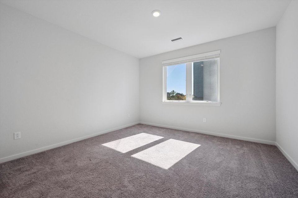 A room with a rug and a window.