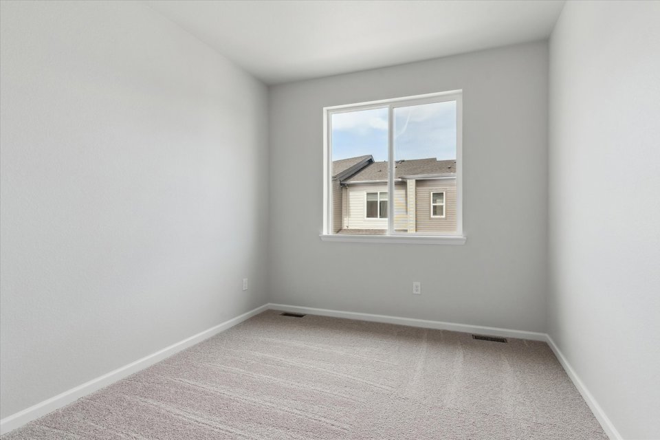 A room with a window and a carpet.