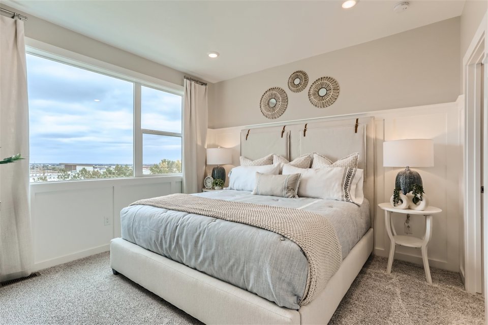 A bedroom with a large window.