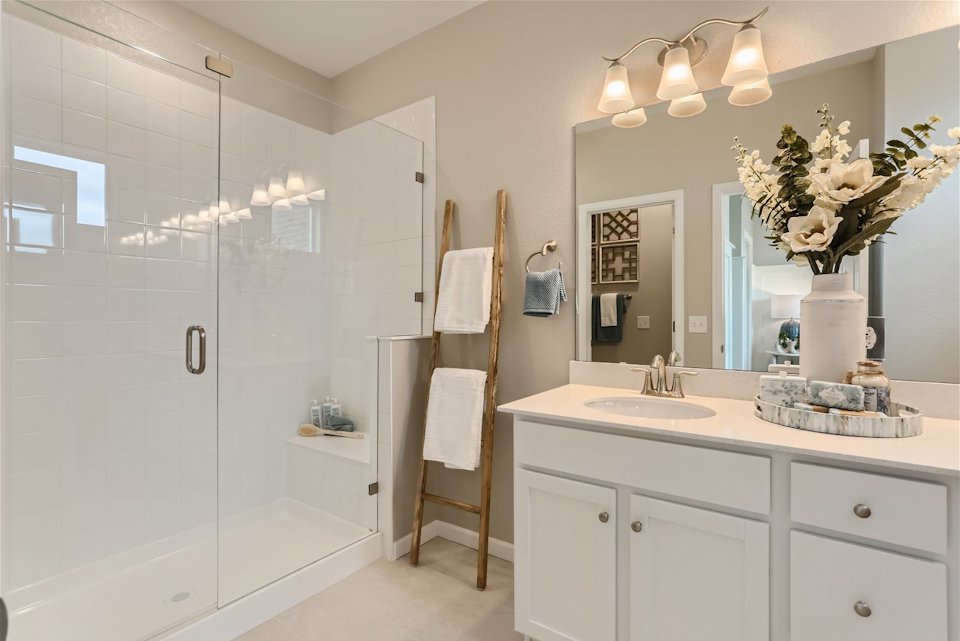 A bathroom with a sink and a shower unit.