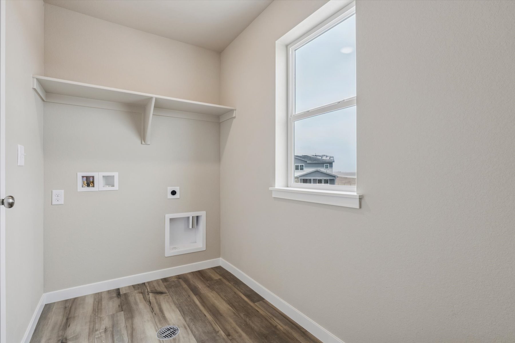 A room with a window and a wood floor.