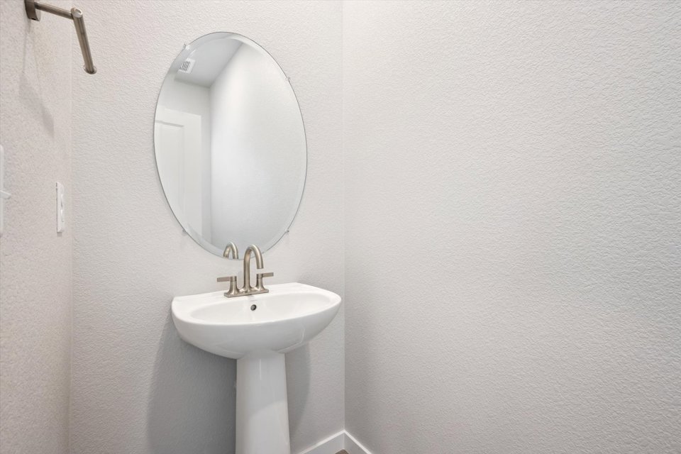 A bathroom with a round mirror.