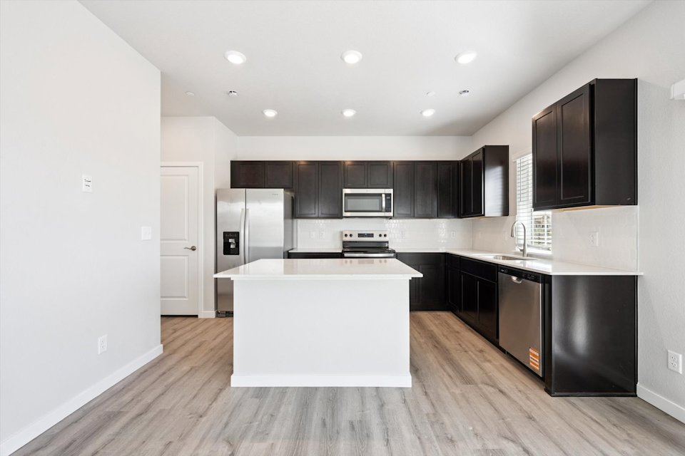 A kitchen with black cabinets.