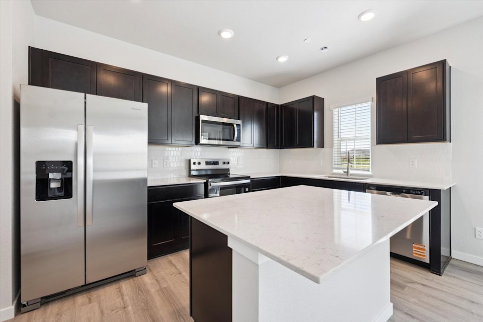 A kitchen with black cabinets.