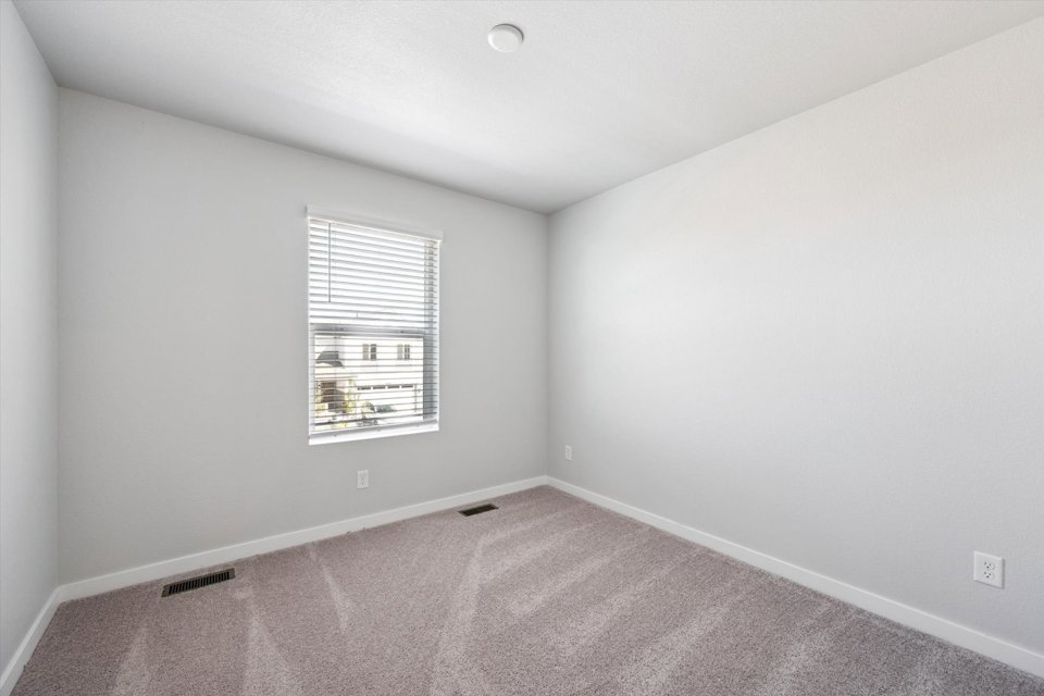 A room with a window and a carpet.