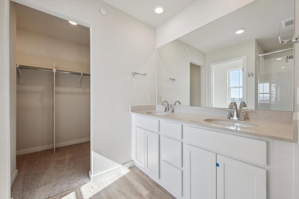 A bathroom with white cabinets.