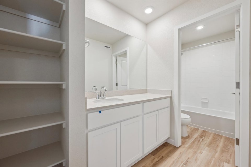 A bathroom with white cabinets.
