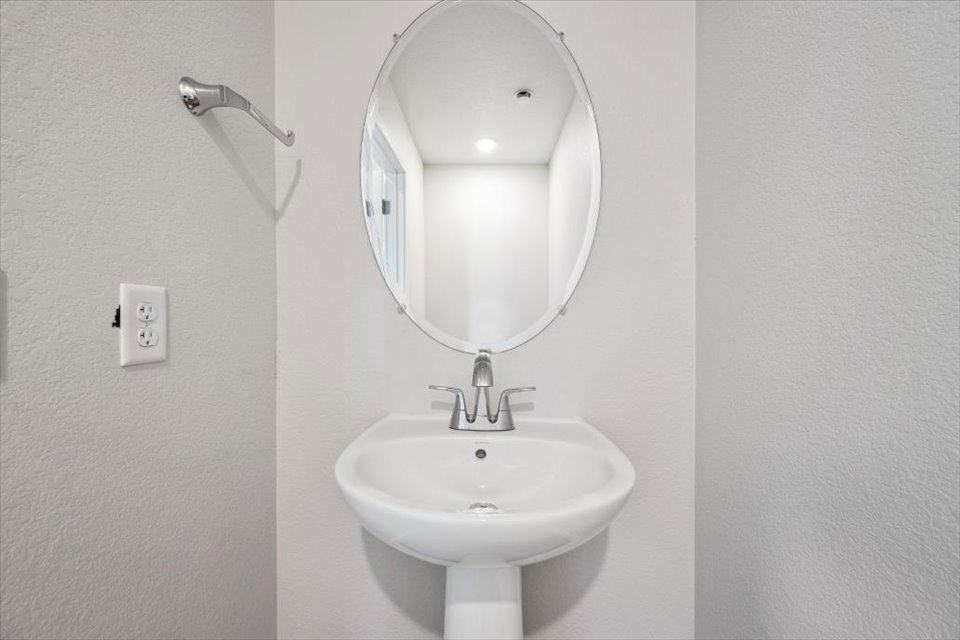A bathroom with a round mirror.