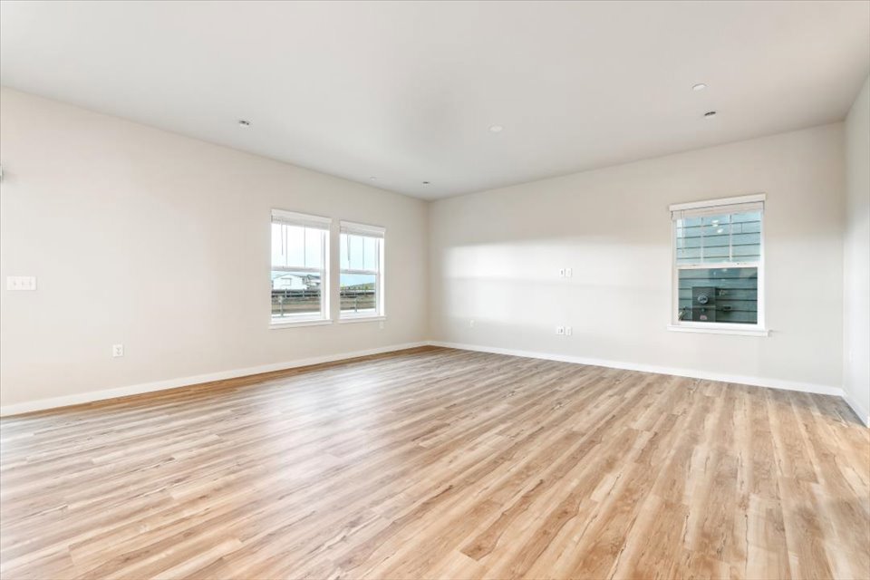 A room with a wood floor and windows.
