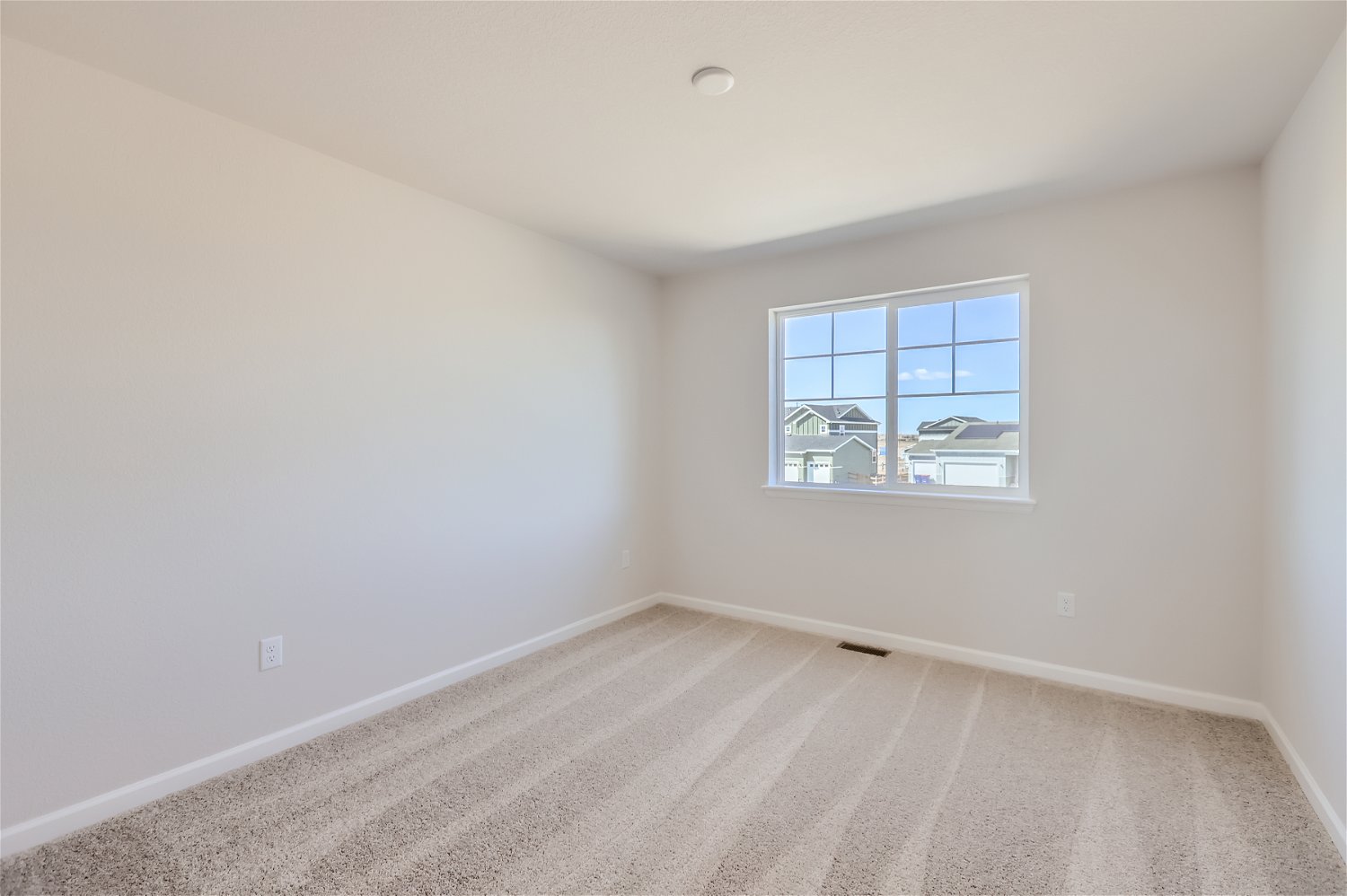A room with a window and a carpet.