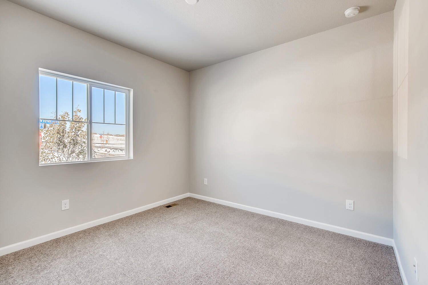 A room with a window and a carpet.