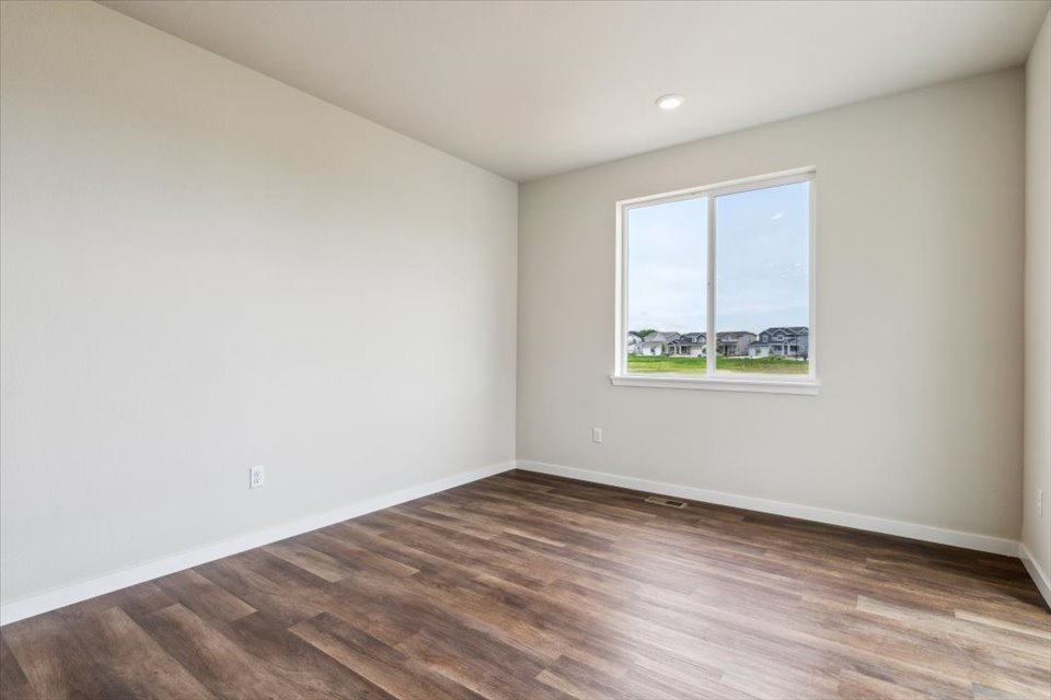 A room with a wood floor and a window.