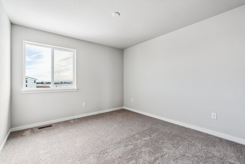 A room with a window and a carpet.