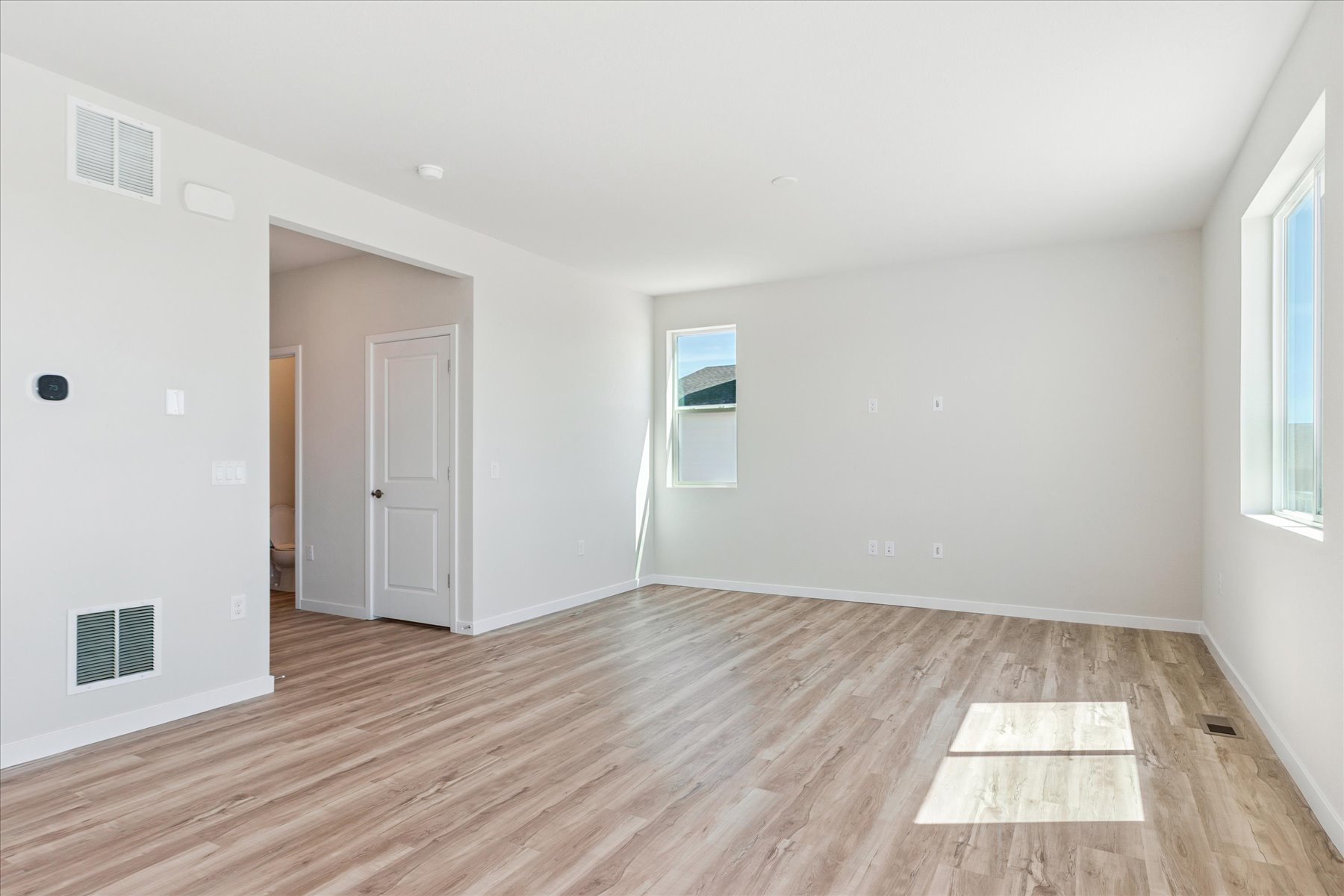 A room with a wood floor and white walls.