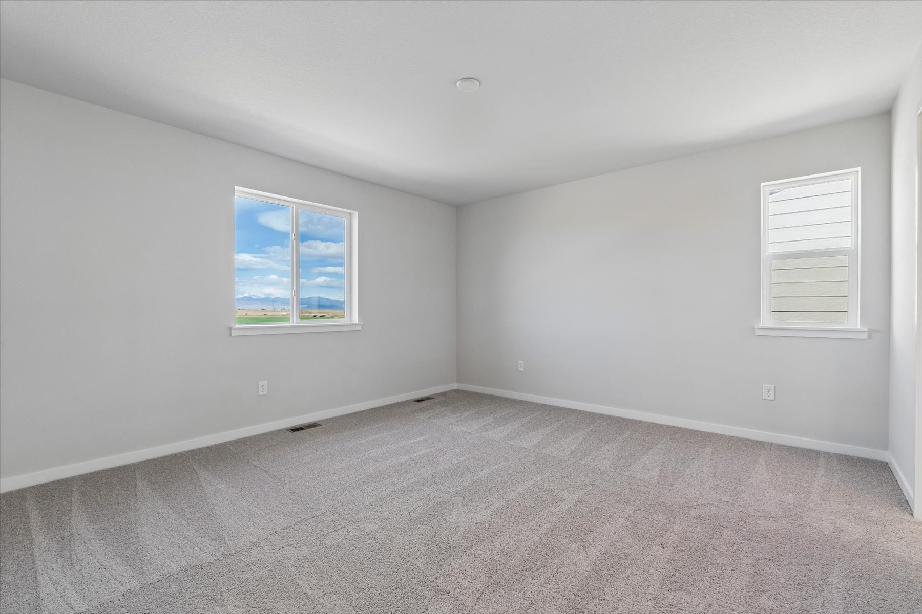 A room with a window and a carpet.
