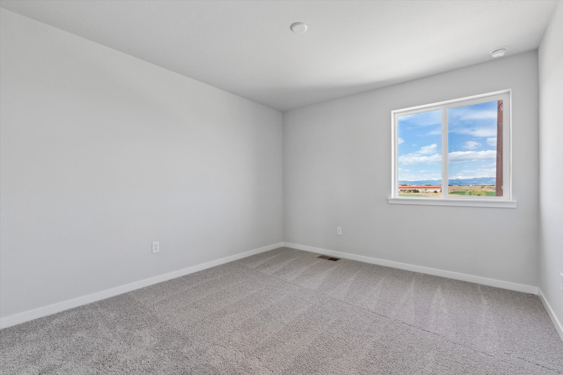 A room with a window and a carpet.