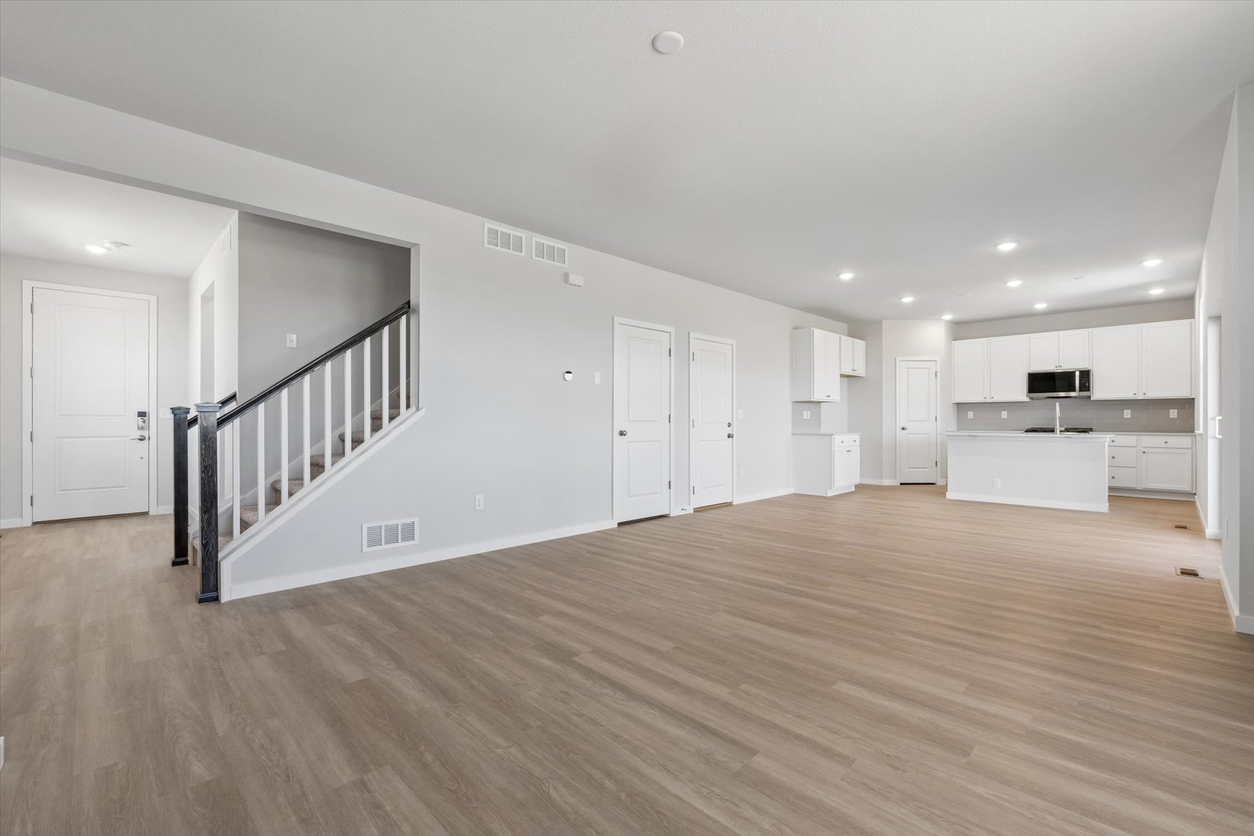 A large empty room with white doors.