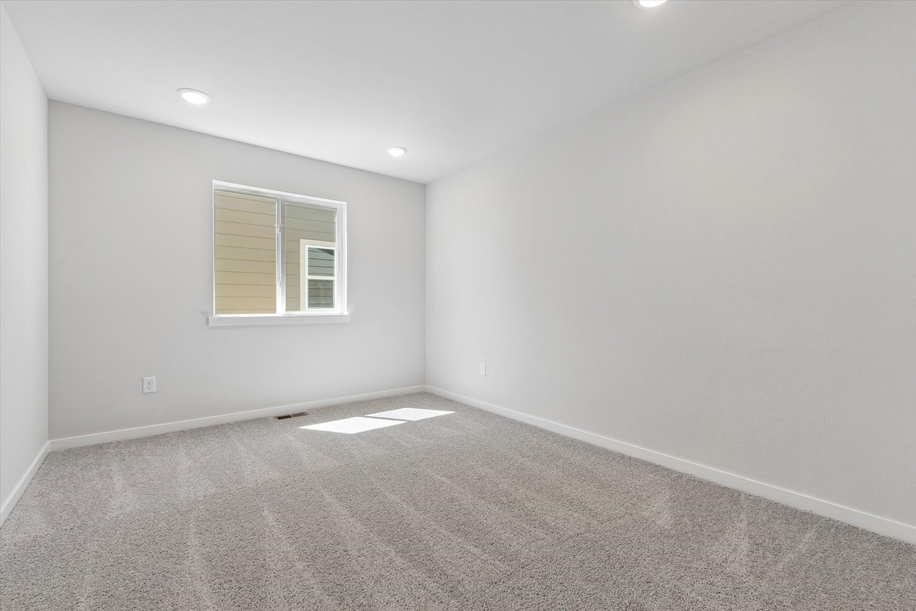 A room with a window and a rug.