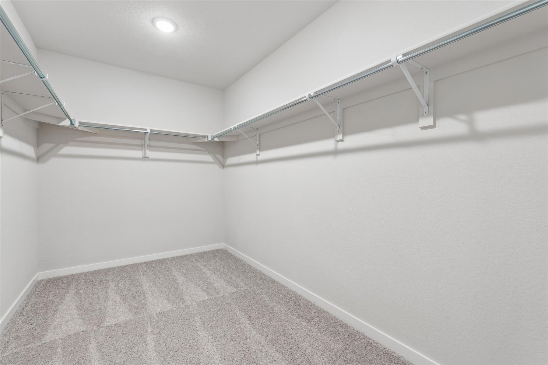 A white room with a grey carpet.