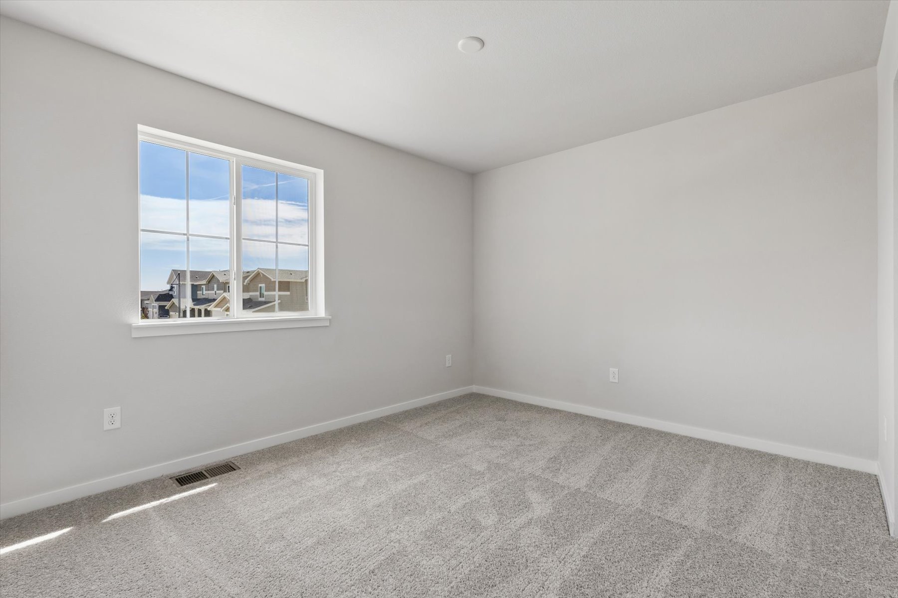 A room with a window and a carpet.