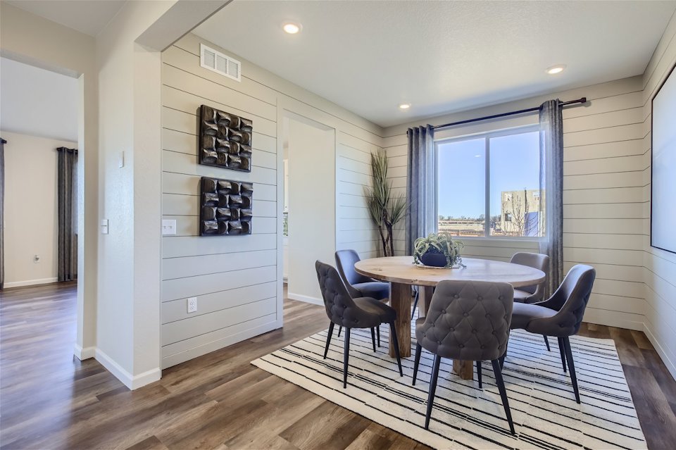 A room with a table chairs and a window.