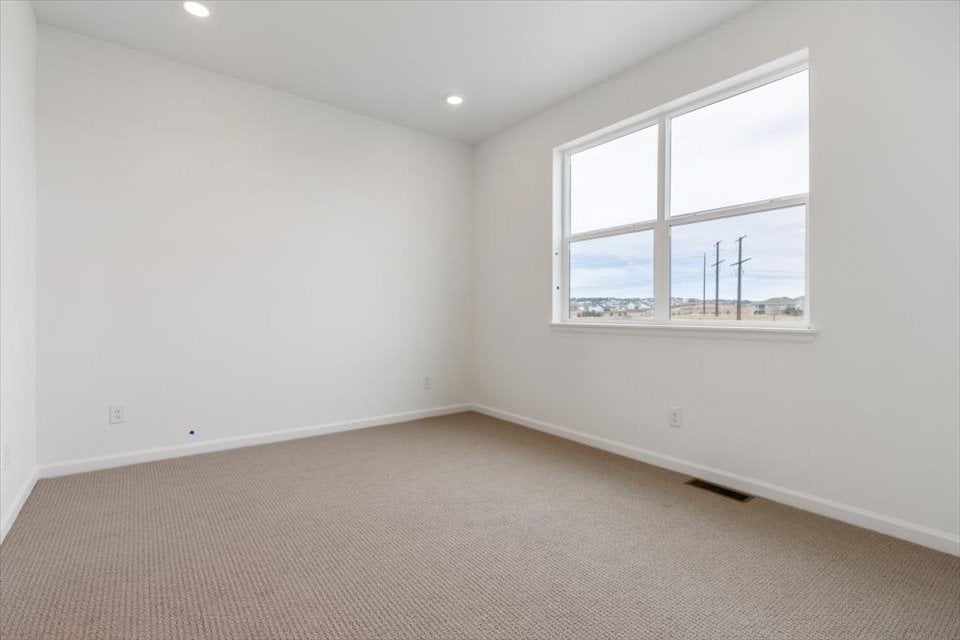 A room with a window and a carpet.