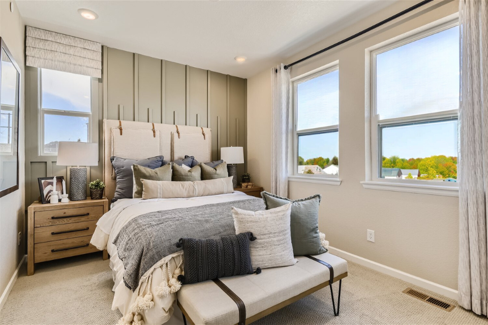 A bedroom with a bed and a bench.