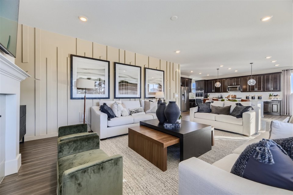 A living room with a large white couch and a wood floor.