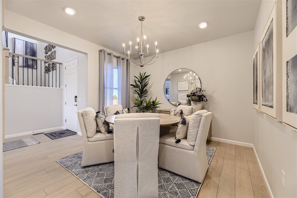 A living room with a white couch and a round mirror.