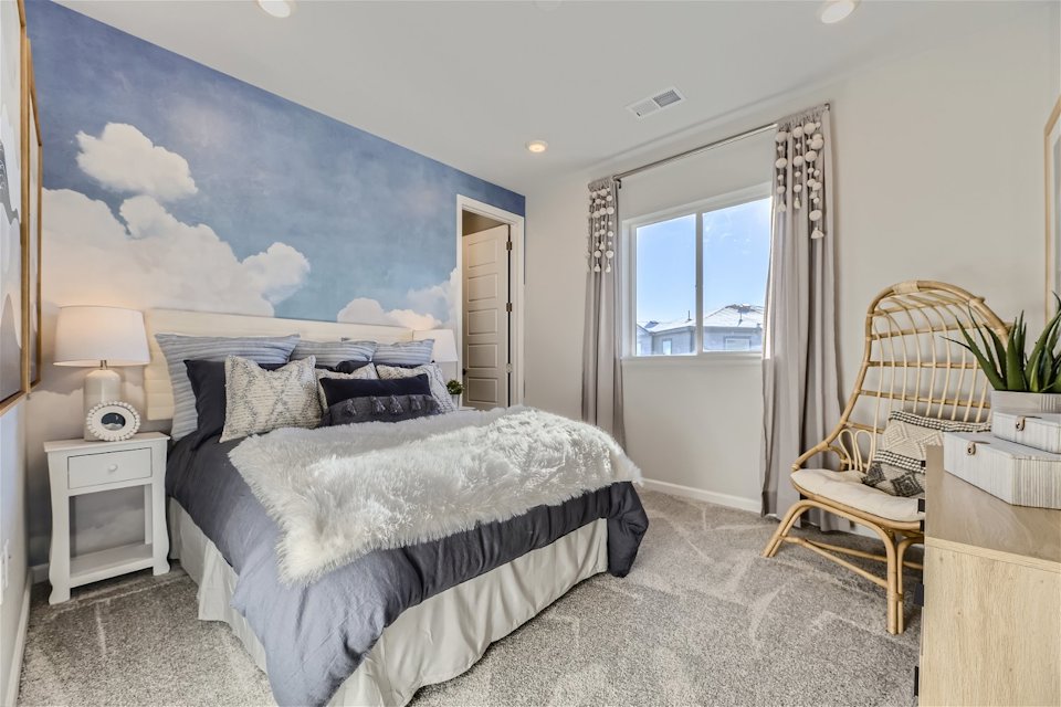 A bedroom with a bed and a chair.