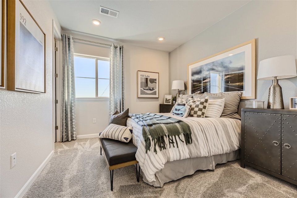 A bedroom with a bed and a bench.