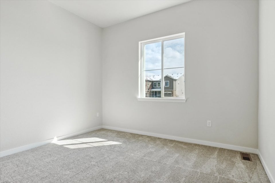 A room with a window and a rug in it.