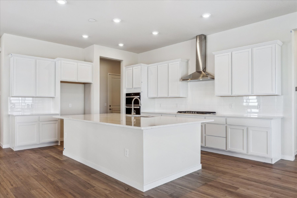 A kitchen with white cabinets.
